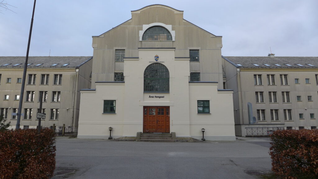 Grå fengselsbygning med skriften "Åna fengsel"over inngangsdøra